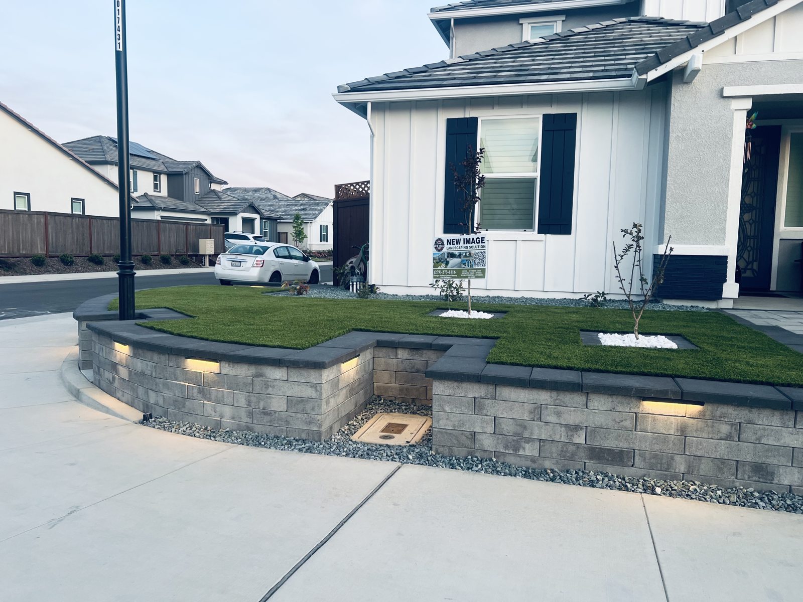 The front entrance combines steps, planting and low walls in a unified layout.