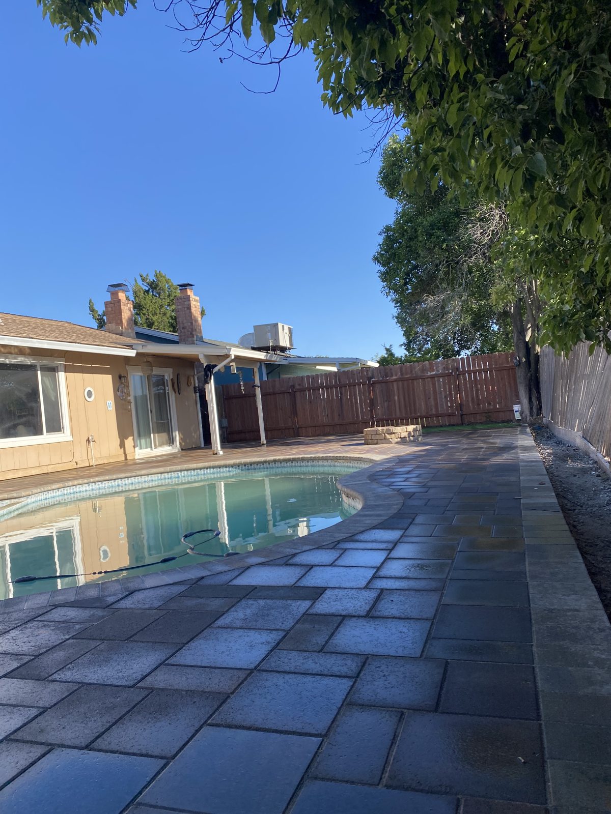 Pavers extend around the pool to create a connected outdoor terrace.