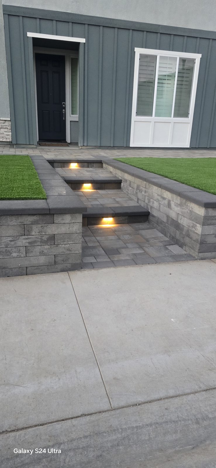 Discreet step lights emphasize the entrance and the texture of the adjacent stone.