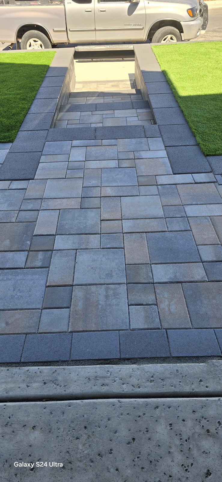 A bordered paver walkway draws a clear line through the front garden.