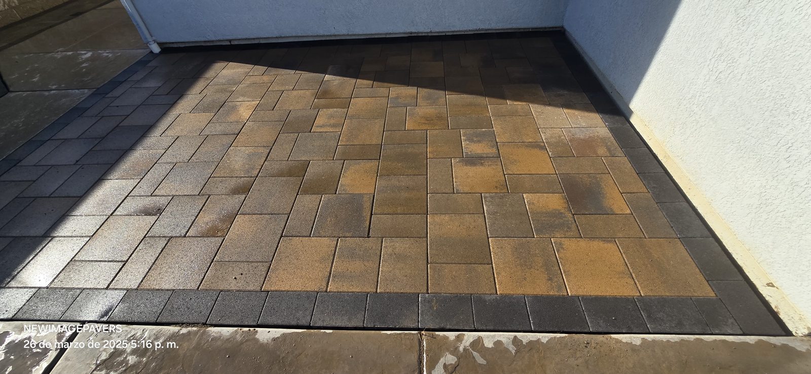 Warm-toned pavers bring texture and contrast to the sheltered patio.