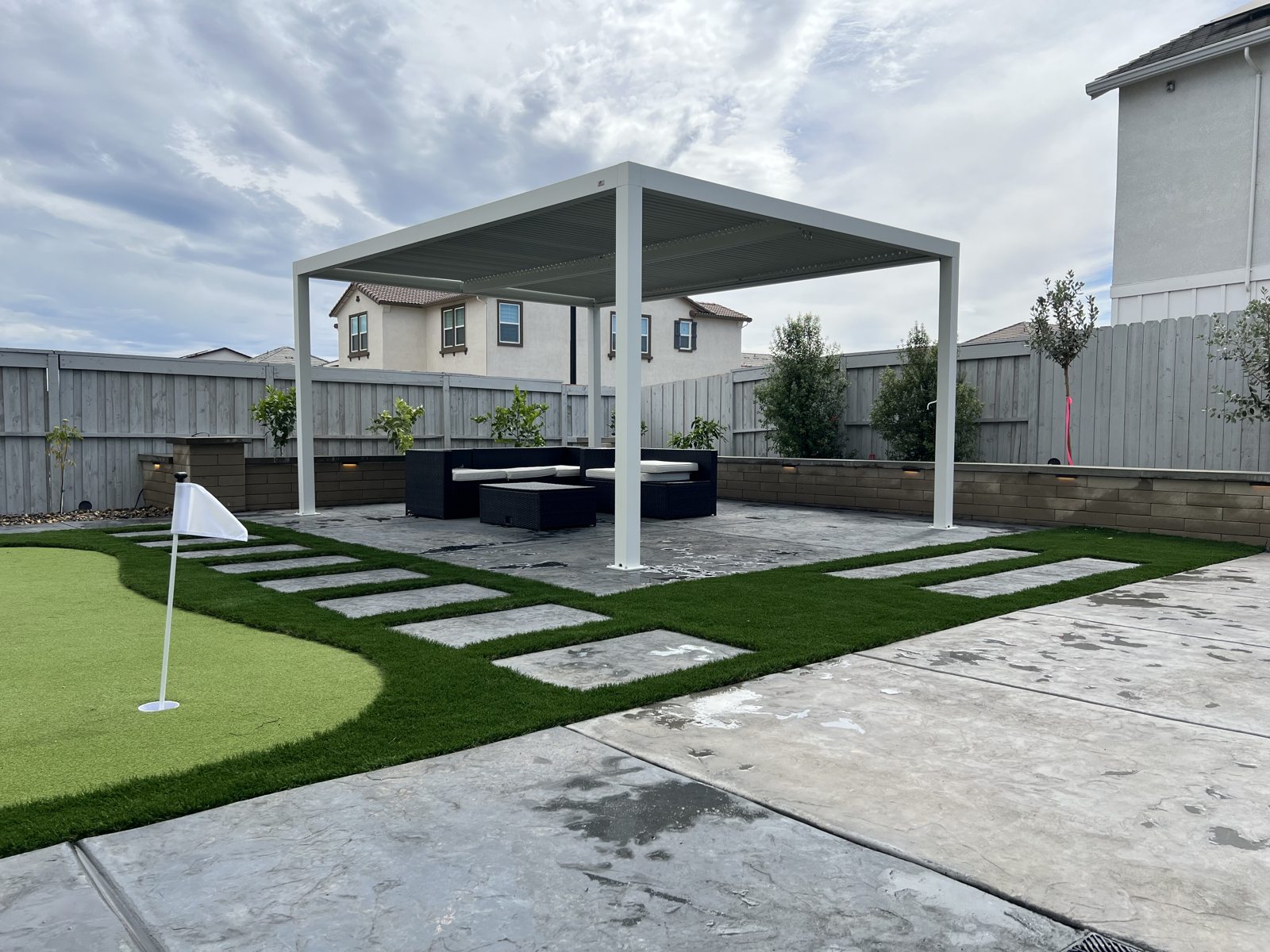 Green lawn, stepping surfaces and a shaded structure form a coordinated retreat.