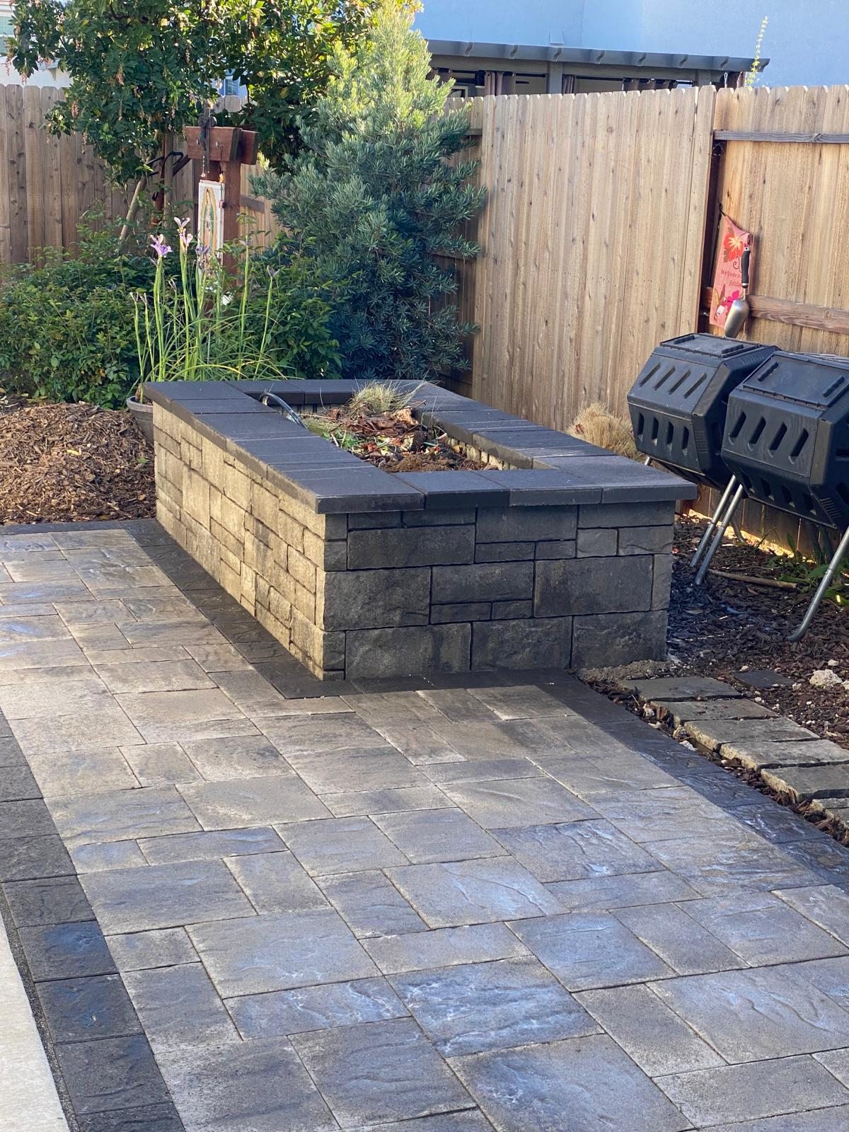A raised stone planter adds dimension and a defined edge to the patio.