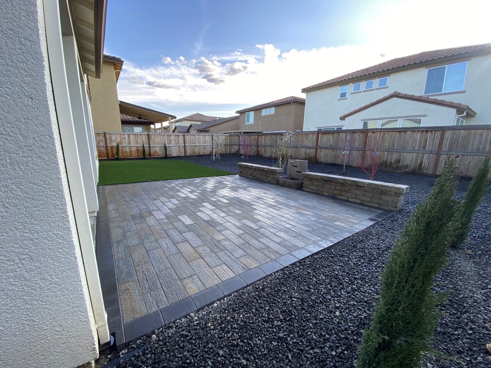 A defined paver surface brings a cohesive finish to the fenced backyard.
