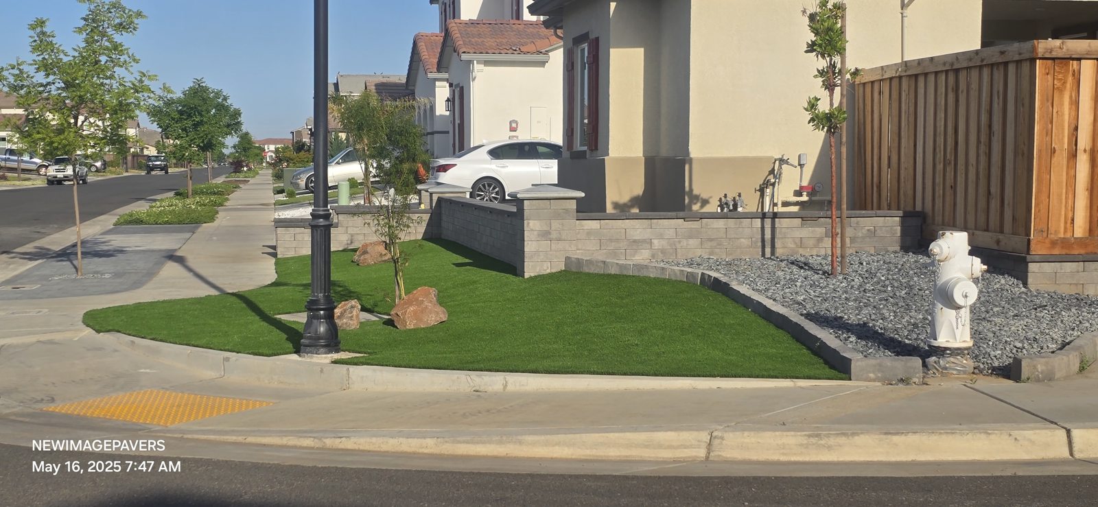 A curved corner garden blends lawn, planting and masonry into the streetscape.