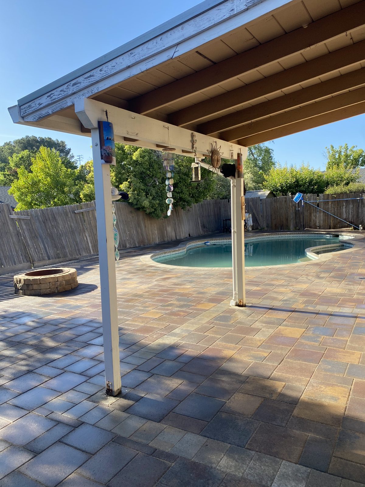 A covered poolside patio combines shade, paving and open views of the water.