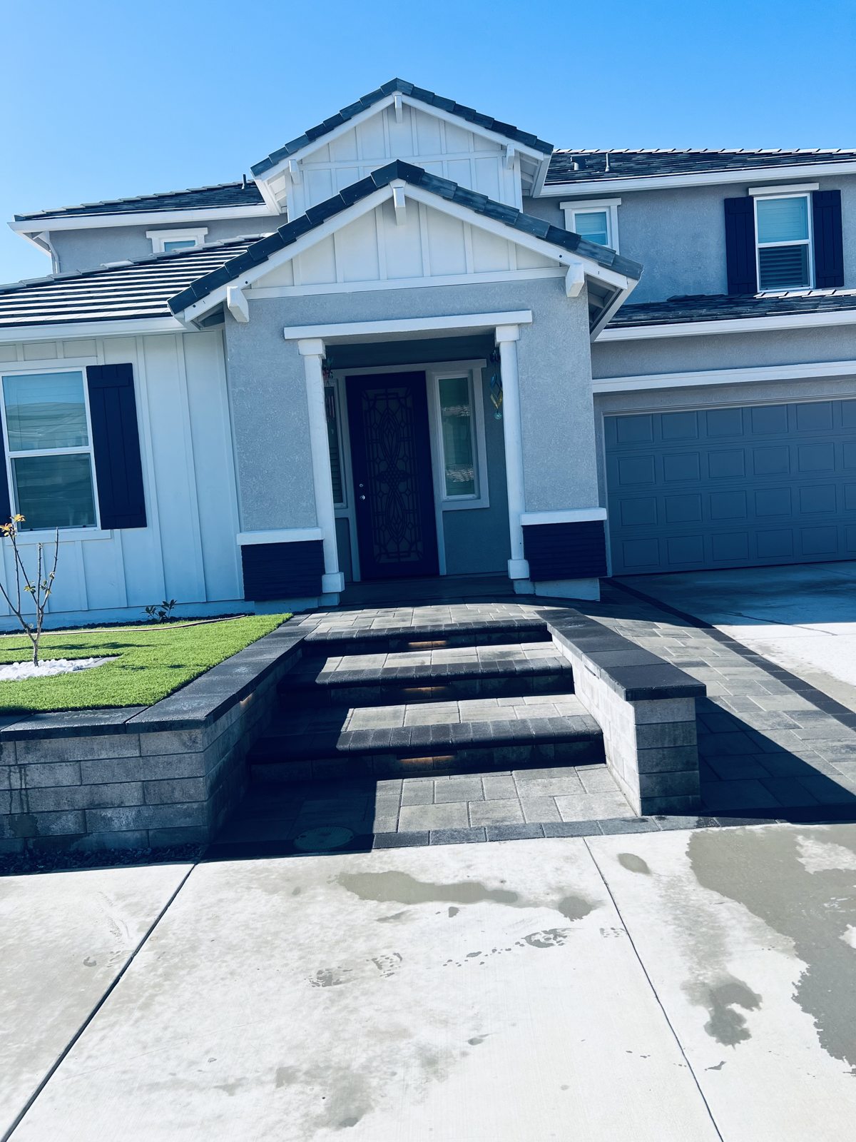 A symmetrical entrance combines pale steps with crisp lawn and masonry edges.