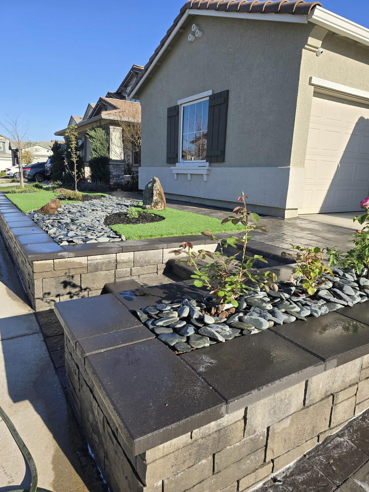 A planted retaining-wall detail adds texture and structure to the front garden.
