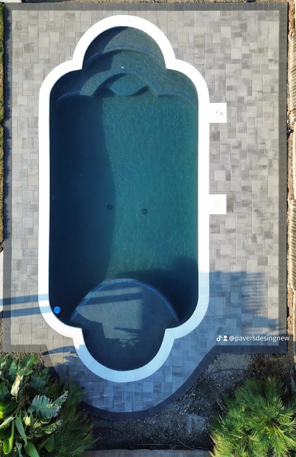 An overhead pool view highlights the shaped waterline and surrounding paving.