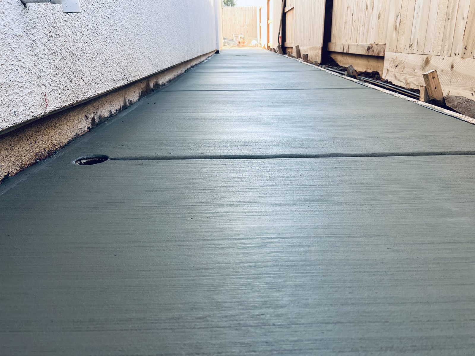A long side-yard concrete passage brings clarity and easy access to a narrow space.