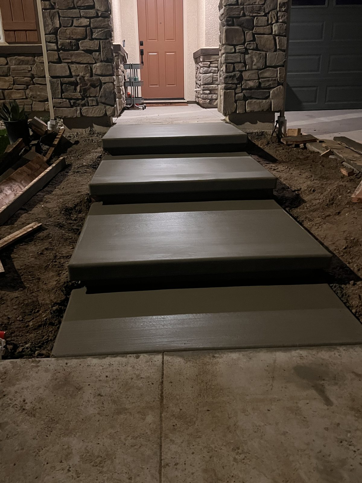 Subtle lighting accents the stepping surfaces along a sheltered approach.