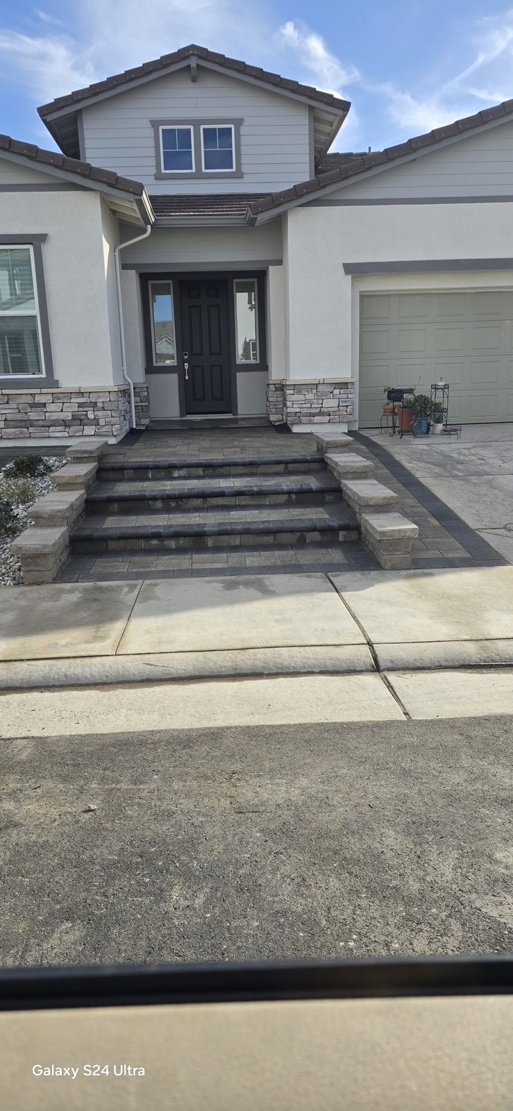 Symmetrical steps and patterned paving lead the eye toward the front door.