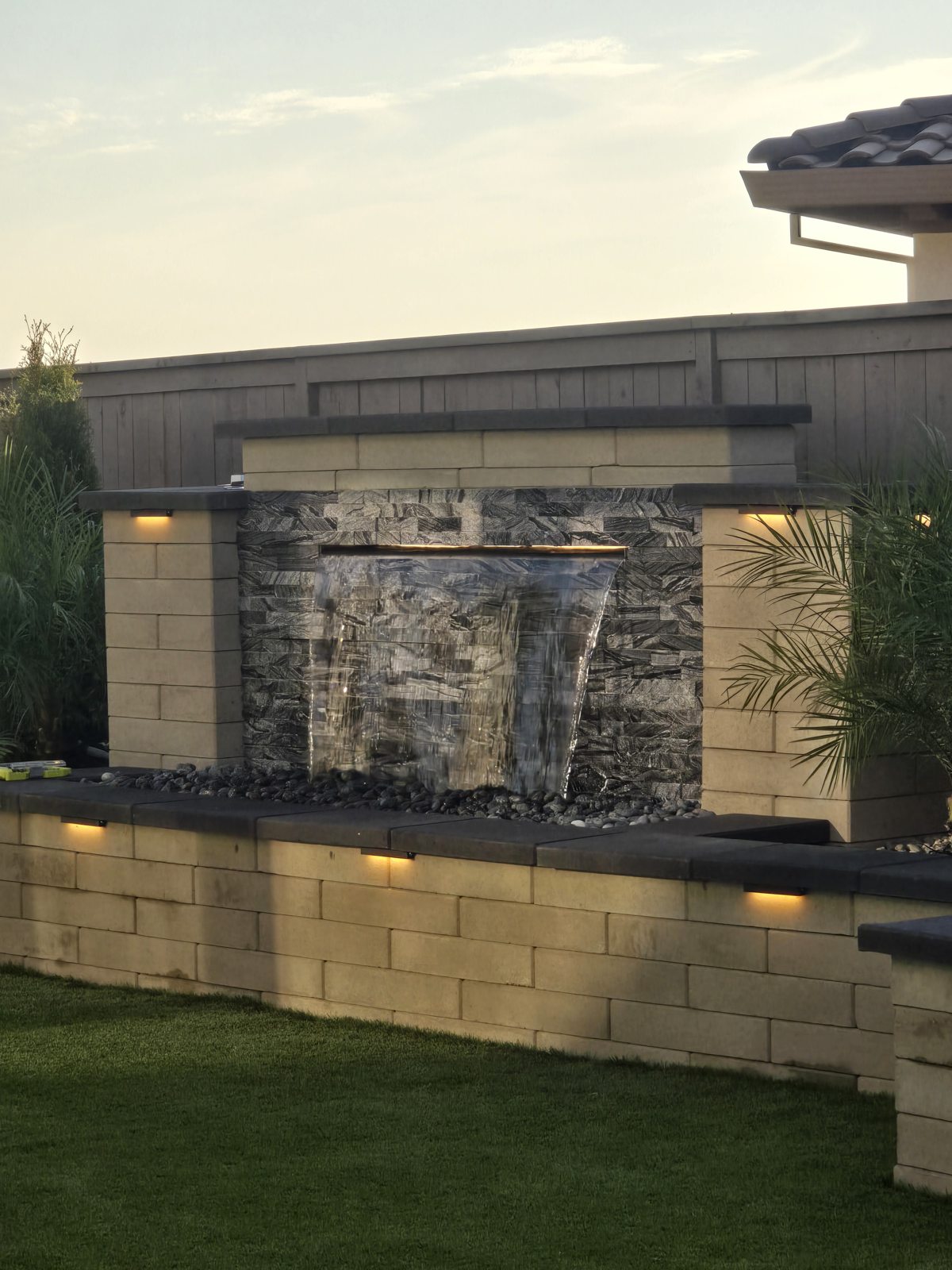 A wide waterfall feature brings movement and texture to the outdoor setting.