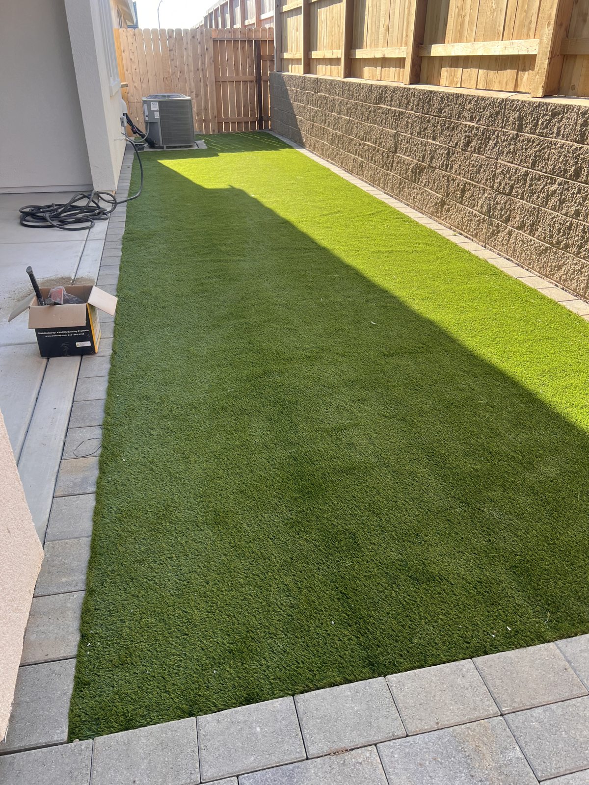 A neat strip of turf brings color and simplicity to a narrow side yard.