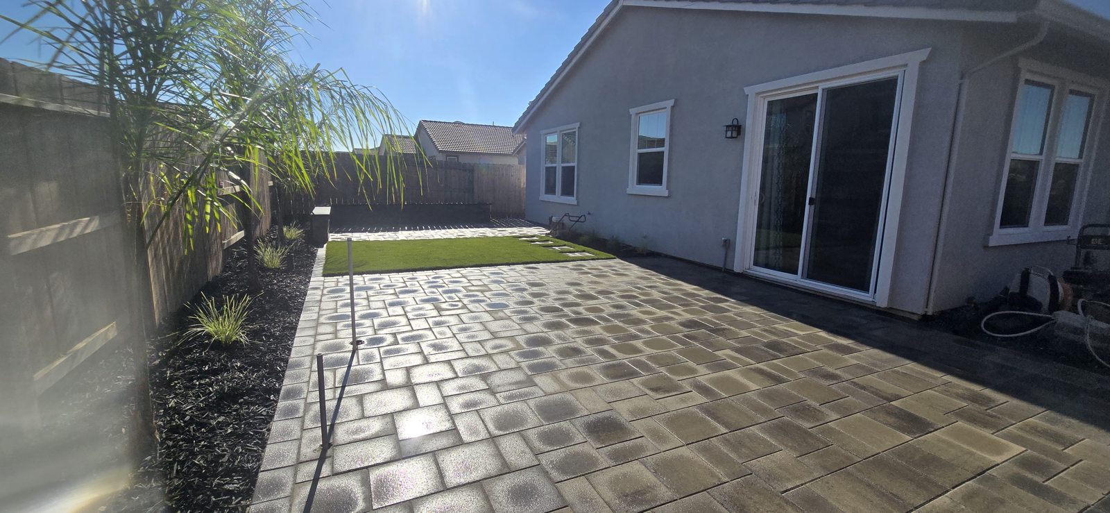 A spacious paver patio opens directly from the home into the backyard.