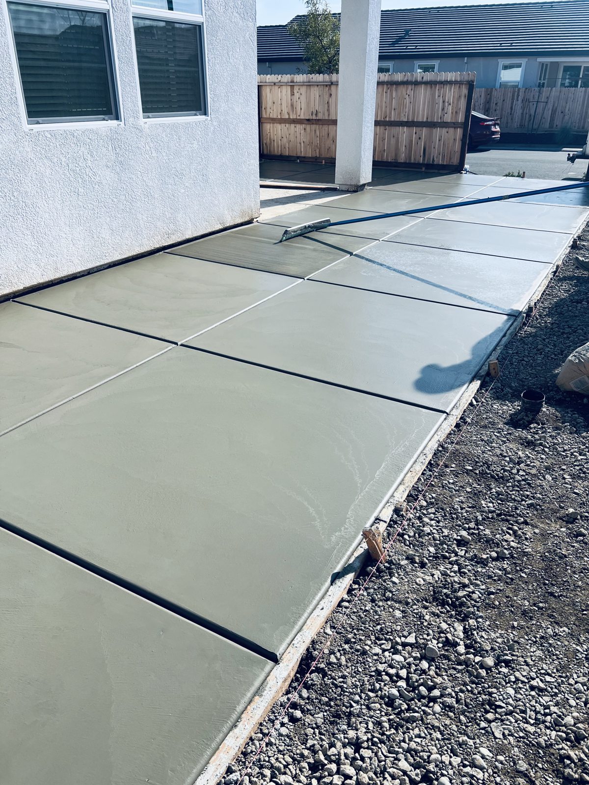 A smooth concrete path follows the side of the home with simple, clean lines.