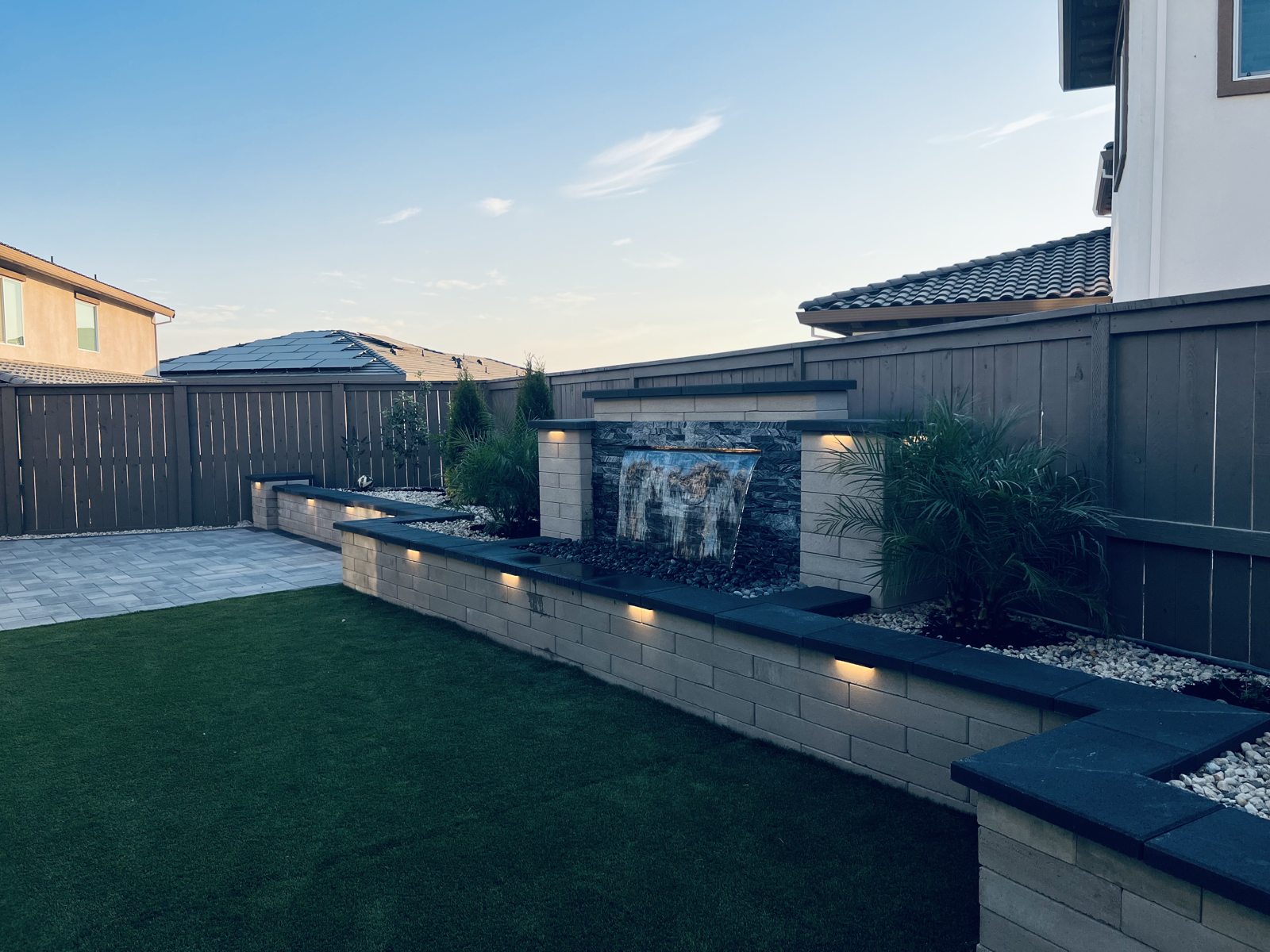 A wide view connects the water wall with the lawn and outdoor terrace.