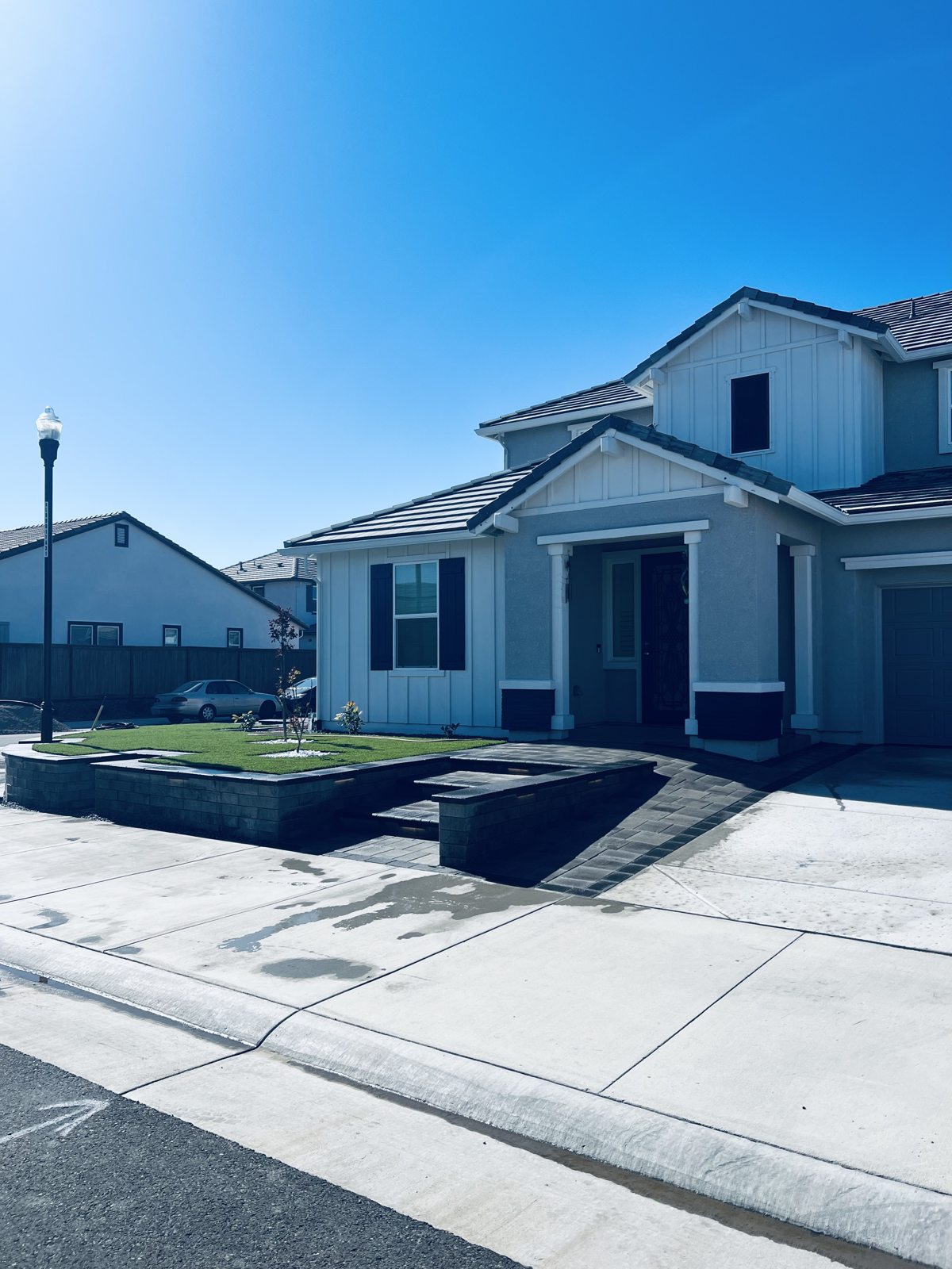 Low walls, paving and green areas give the front yard a structured composition.