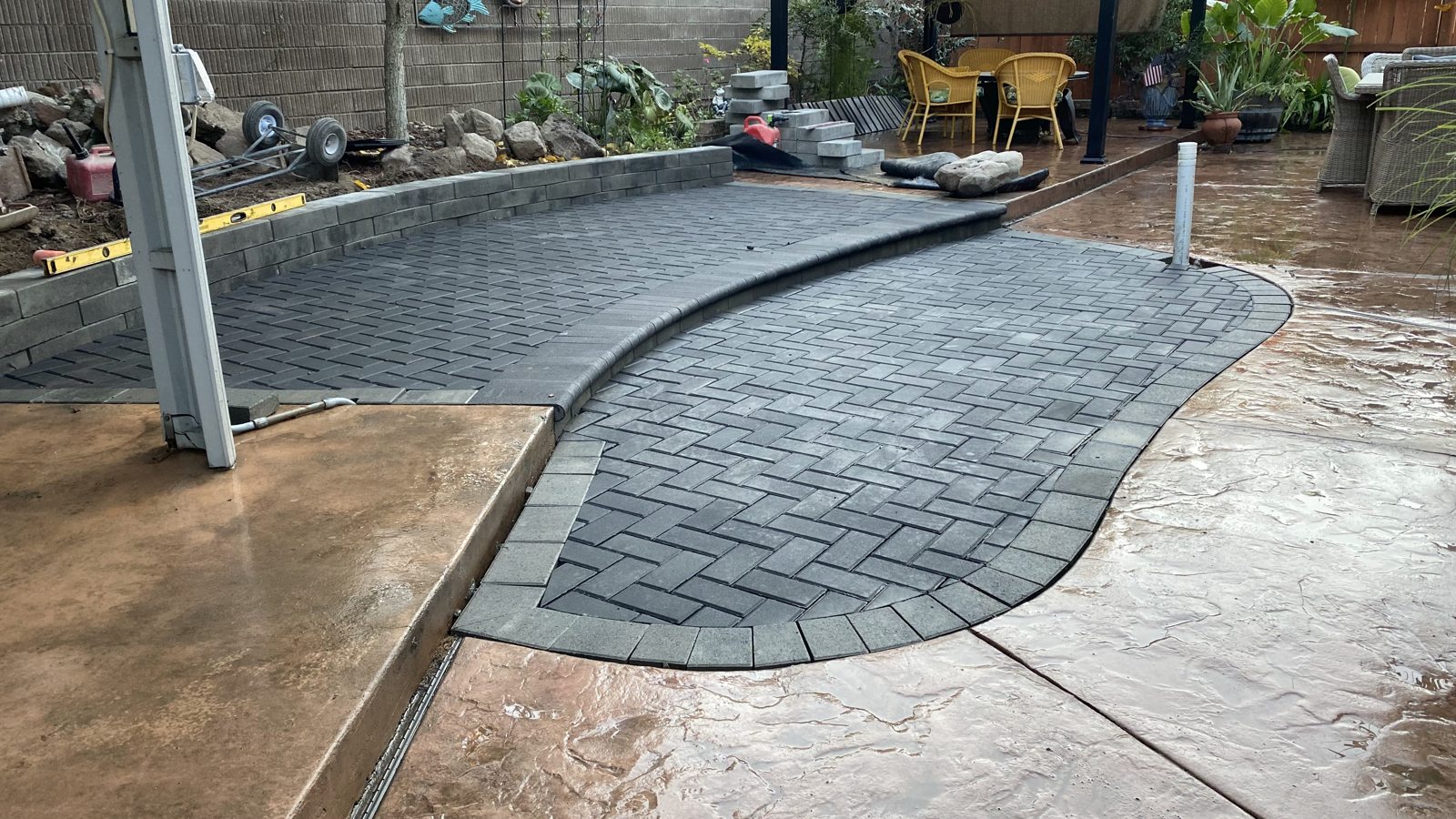 A rounded paver terrace blends naturally with the surrounding garden.