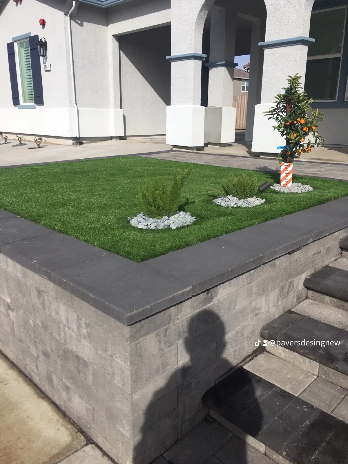 A sculpted garden edge frames the green lawn beside the home.