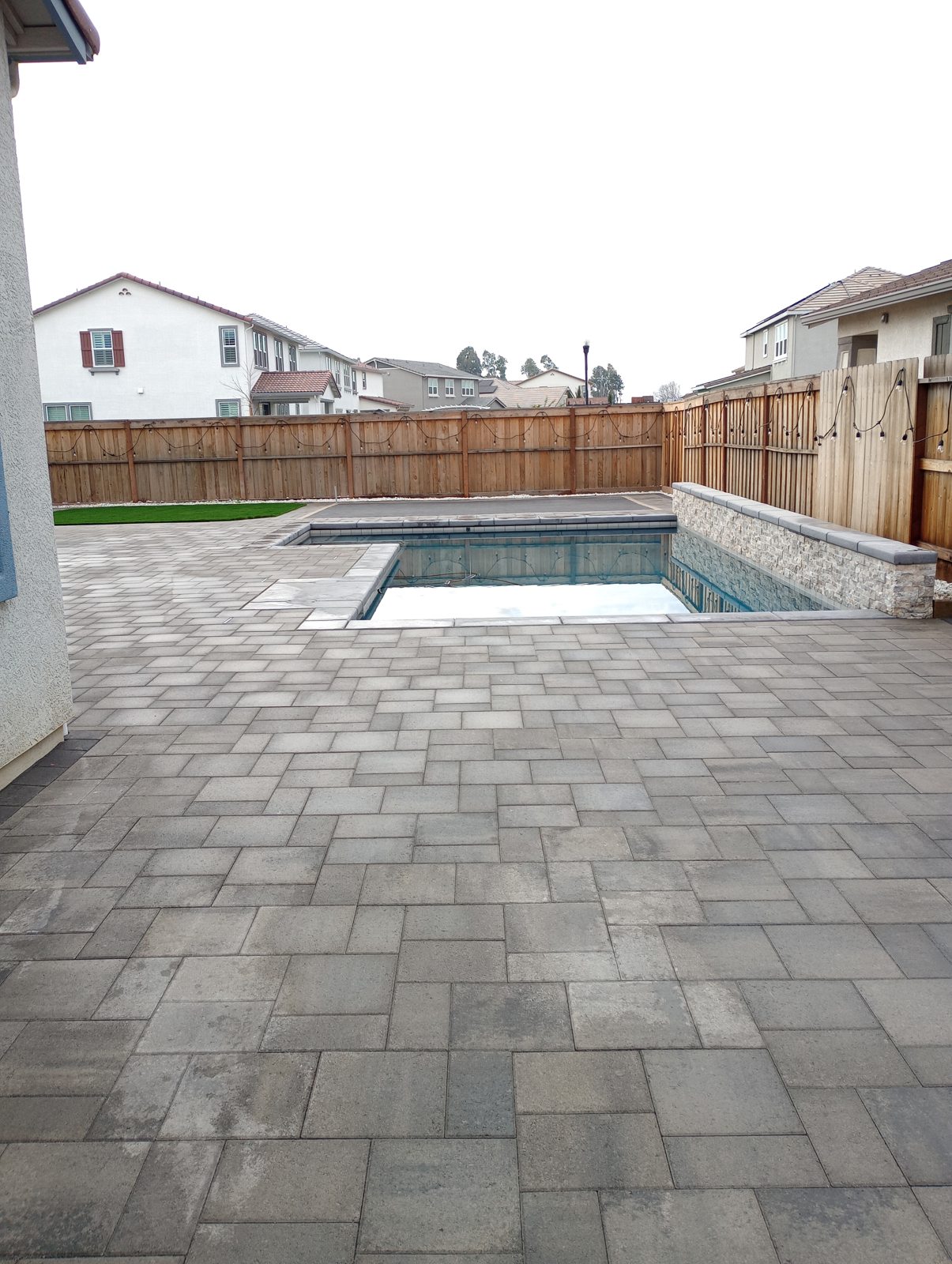 A broad gray paver terrace gives the pool a spacious, coordinated setting.