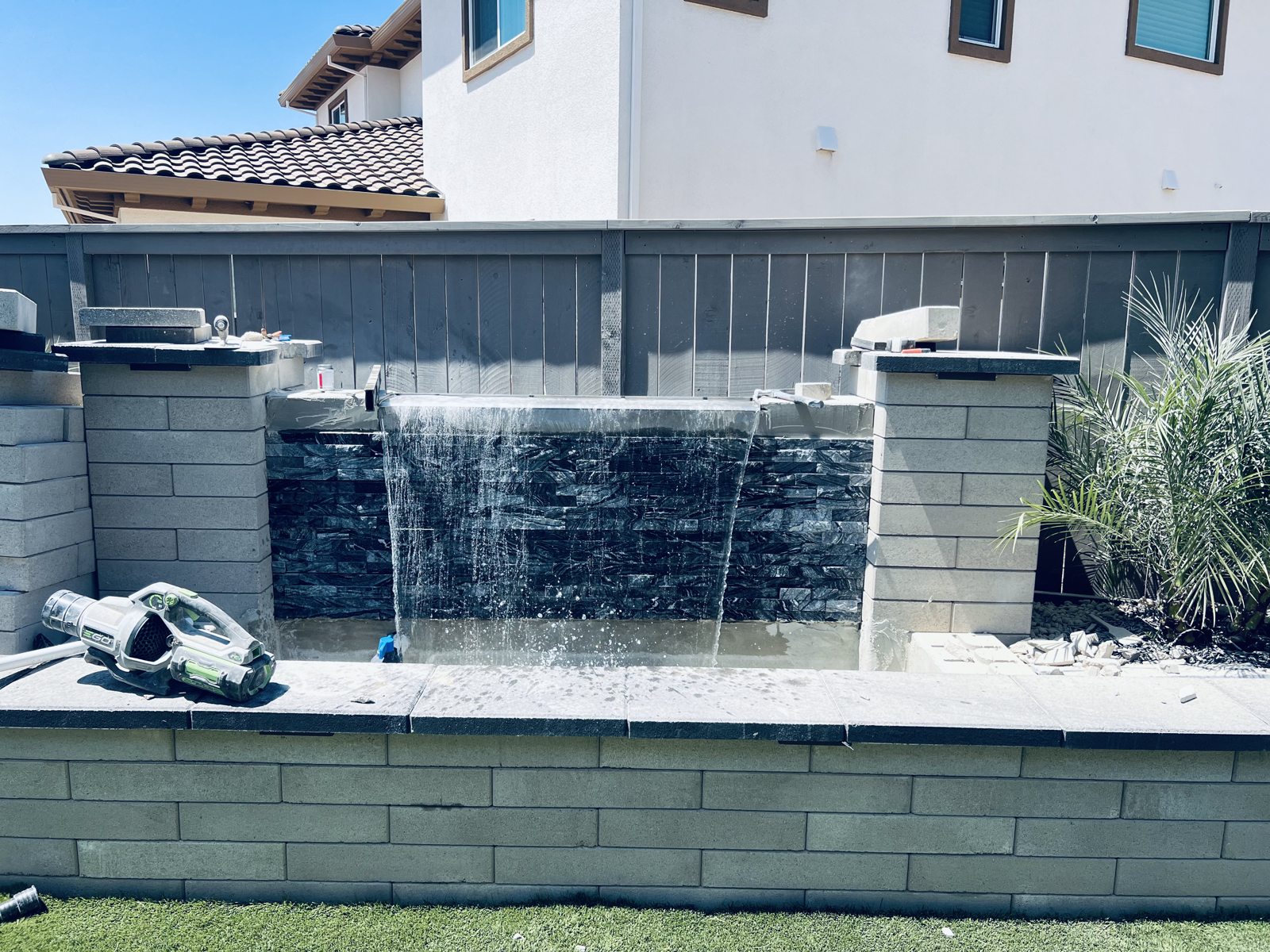 Falling water adds a lively contrast to the textured stone facade.