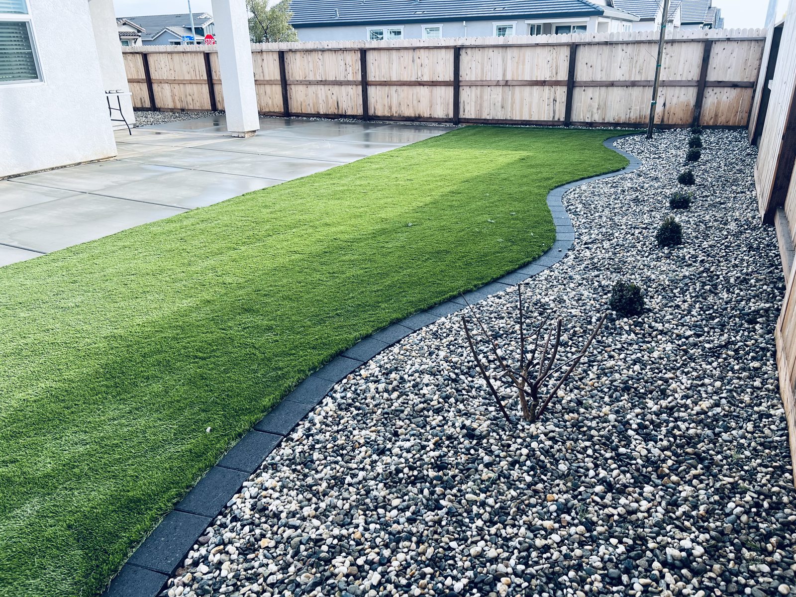 A sweeping turf edge meets decorative stone for a clean, flowing garden border.
