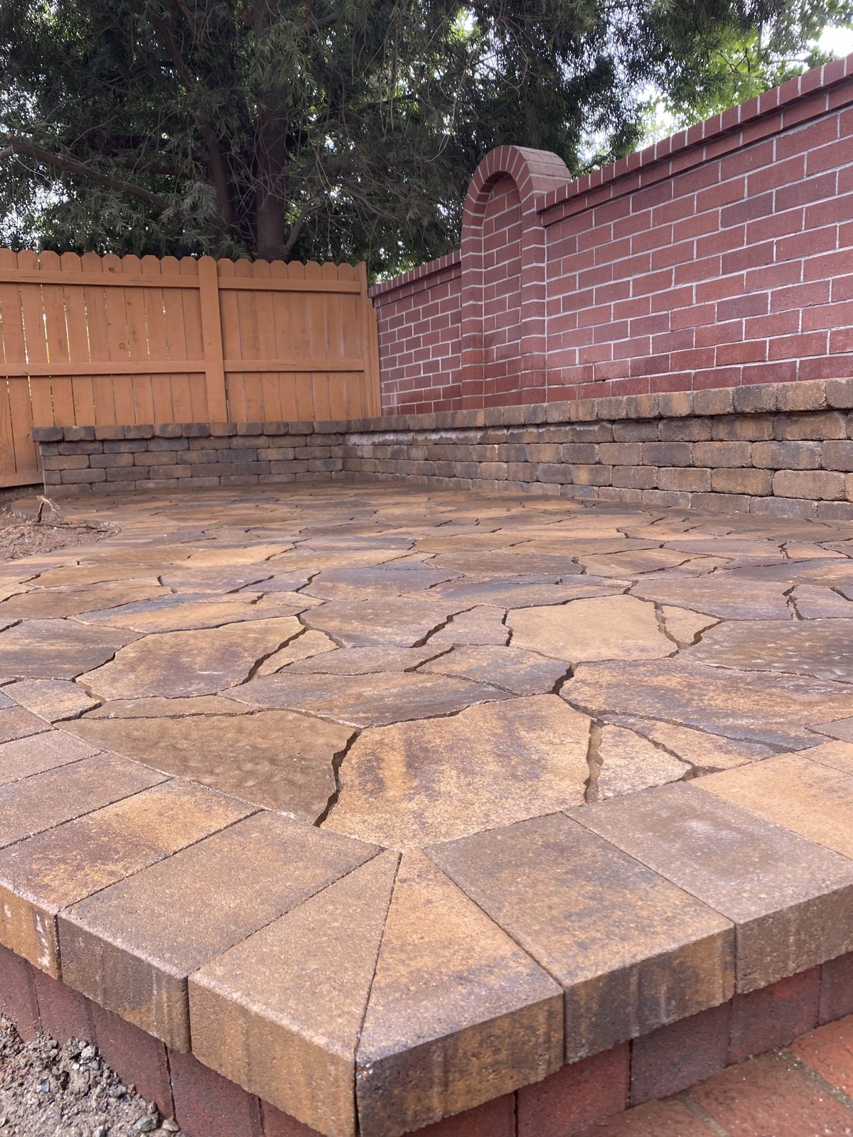 Warm stone tones and organic joints create an inviting garden terrace.