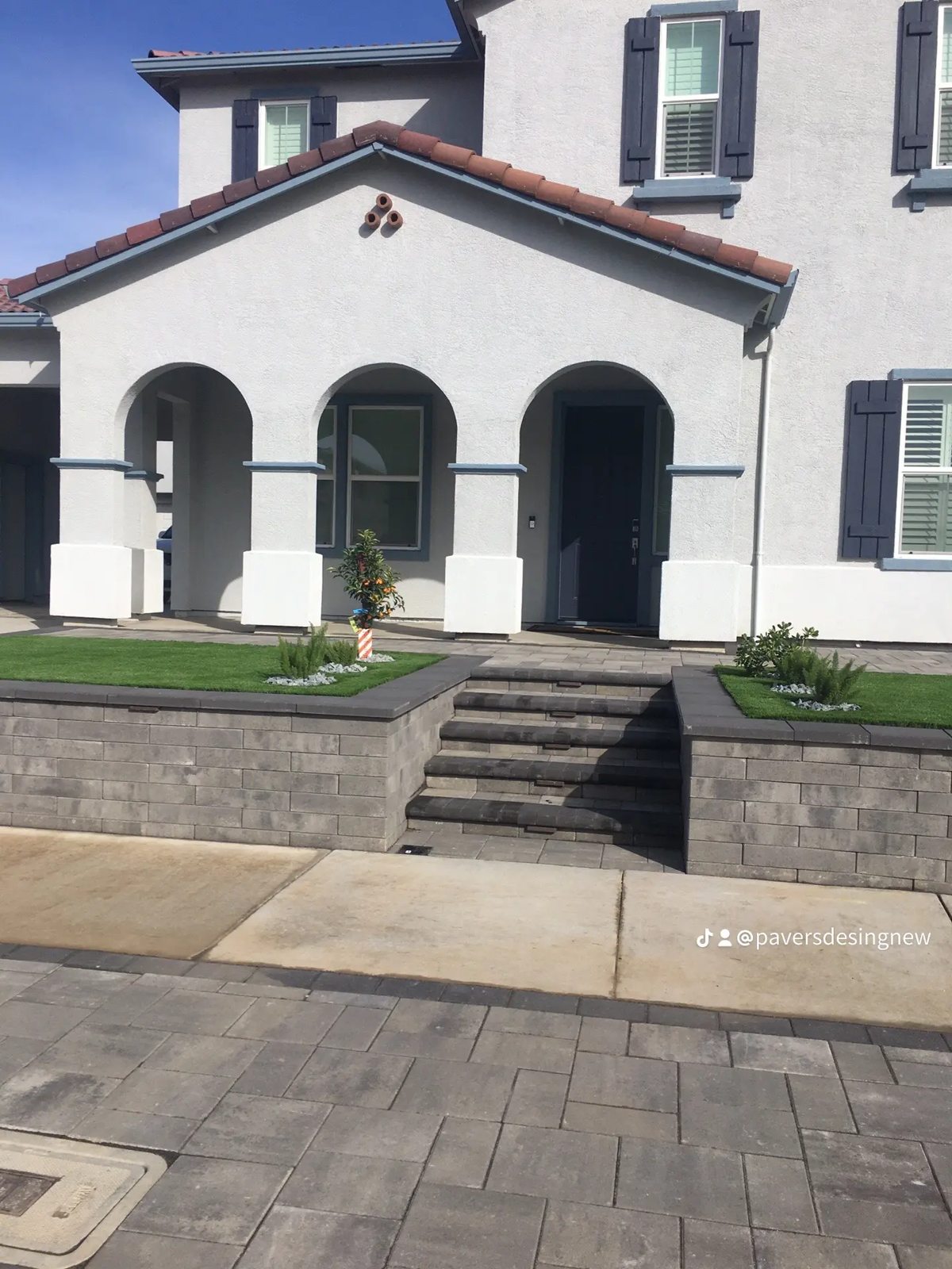 A stepped entrance and low walls complement the home’s architectural character.