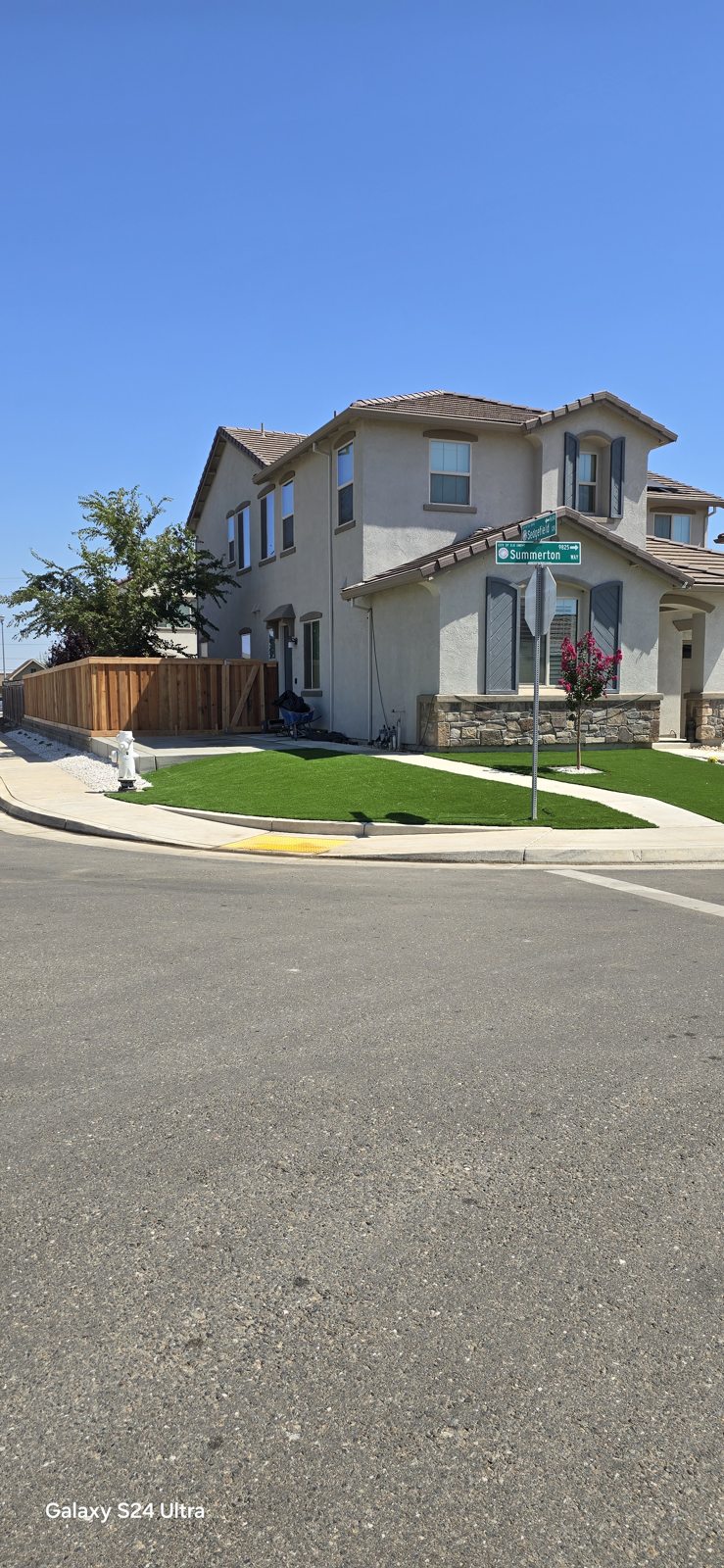 The front landscape combines low walls and green areas for a welcoming street view.