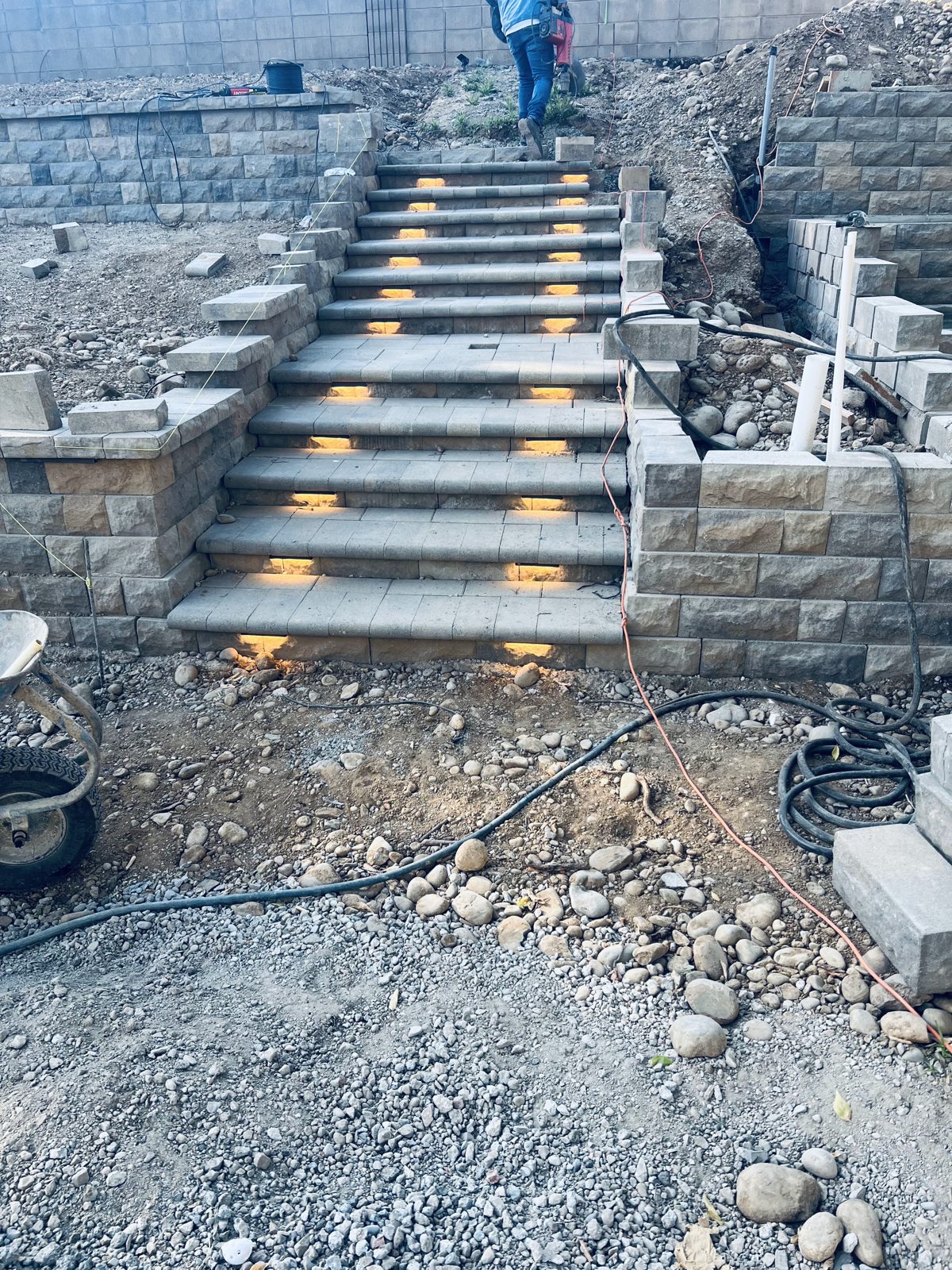 A construction-stage view shows lighting integrated into a terraced outdoor stairway.
