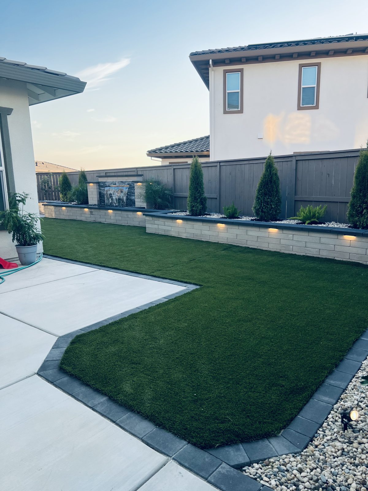 A curved lawn fits neatly between the home and the paved backyard edge.