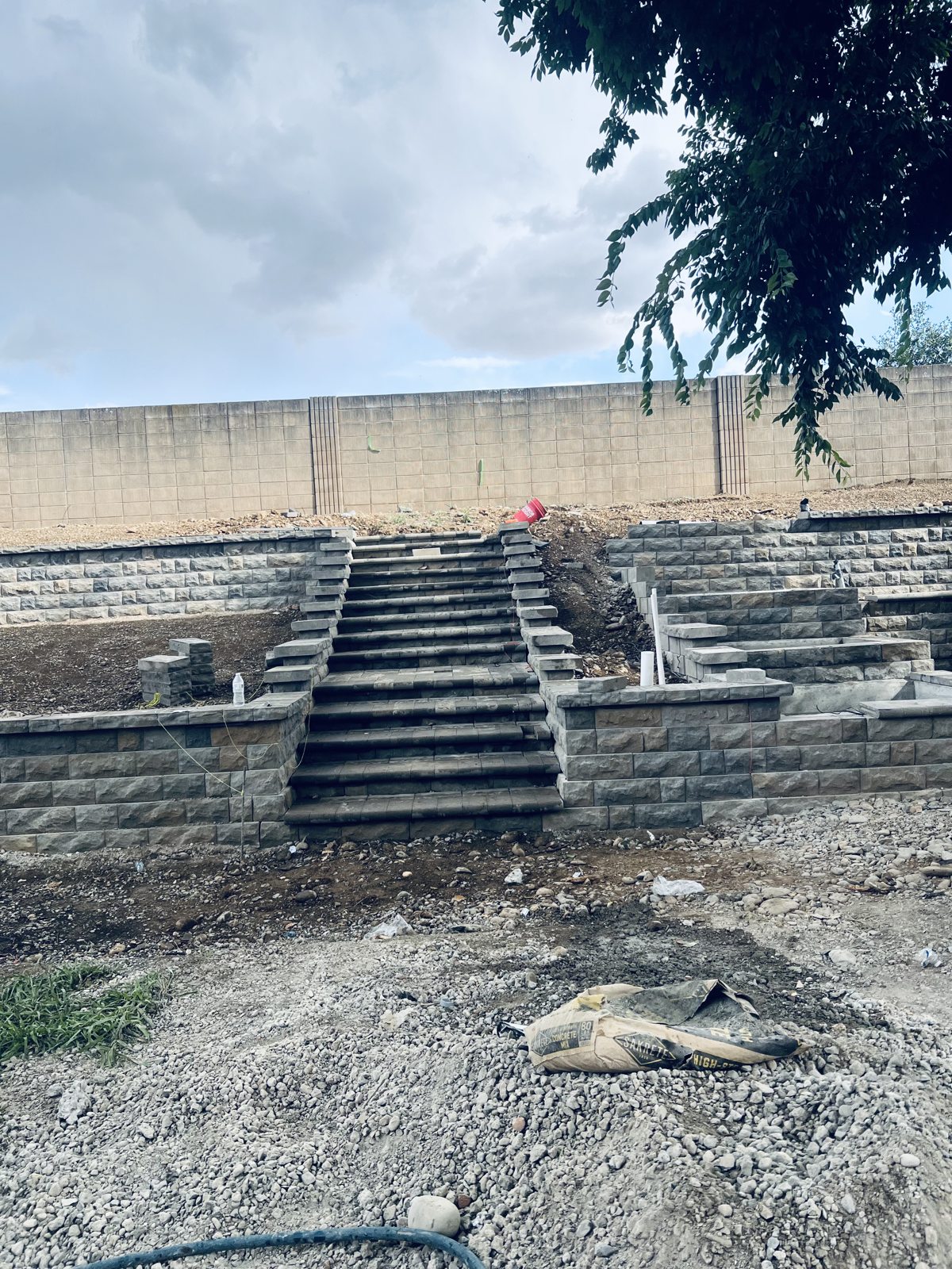 A terraced wall and stairway take shape during the outdoor construction process.
