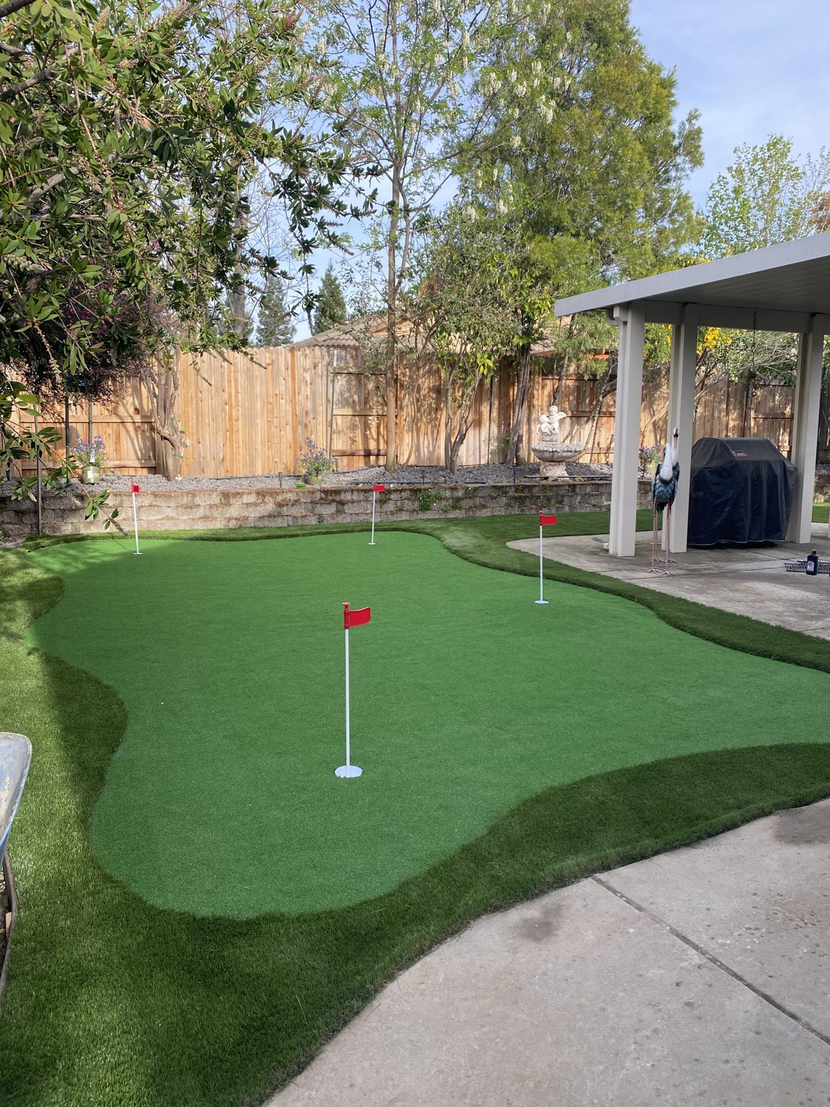 A private putting green adds a dedicated leisure area beside the patio.
