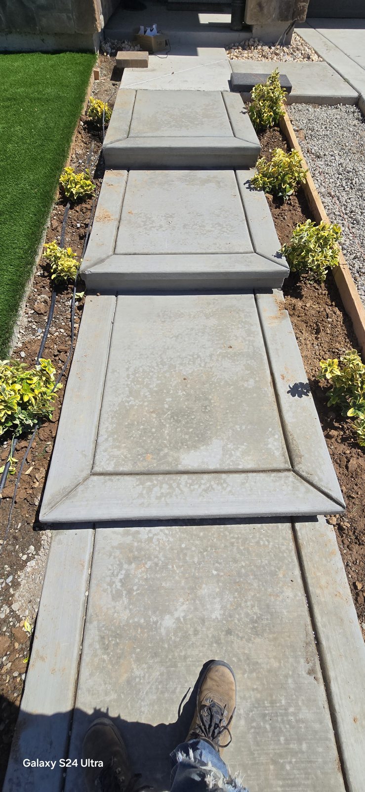 Stepping surfaces and planted borders create a measured approach to the entrance.