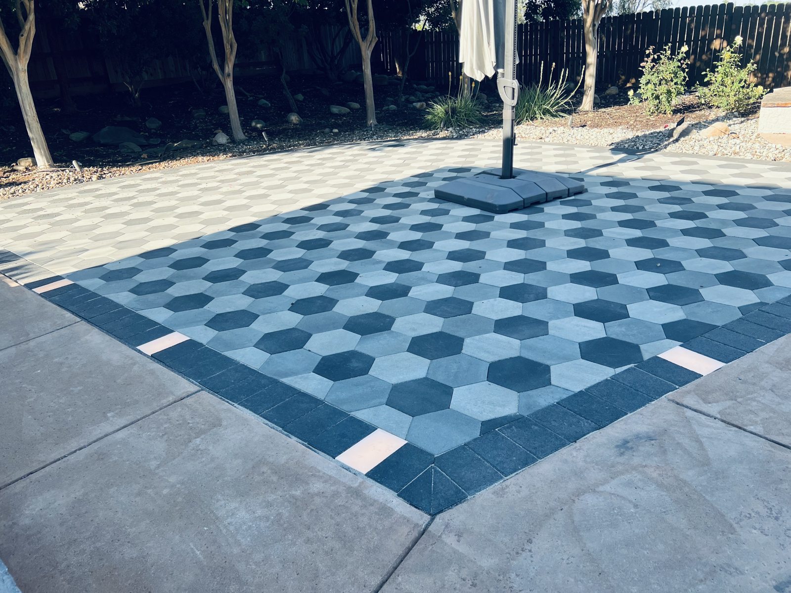 Alternating paver tones create a striking geometric pattern across the patio.