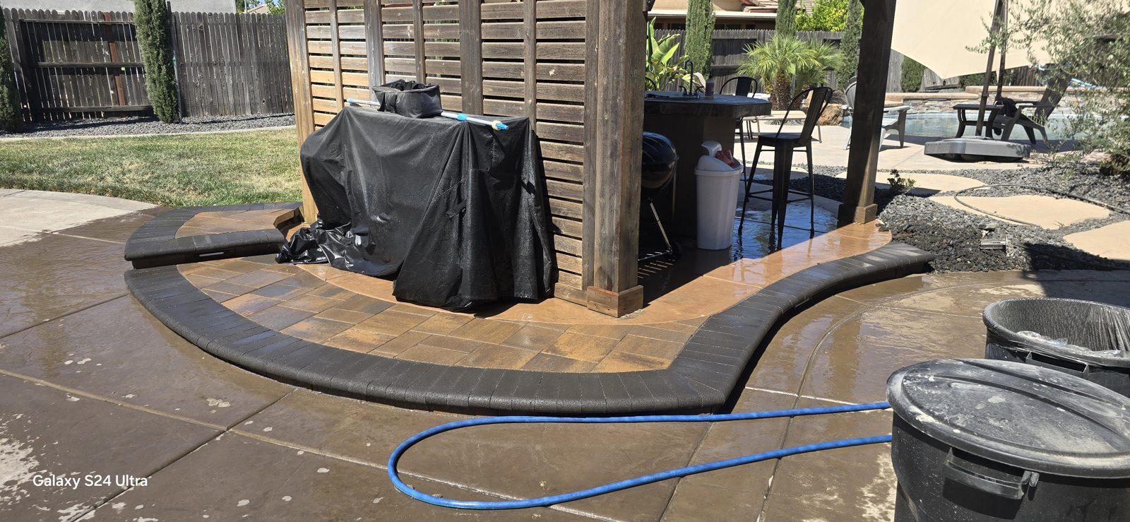 Curved paving wraps around the outdoor gathering area with a flowing transition.