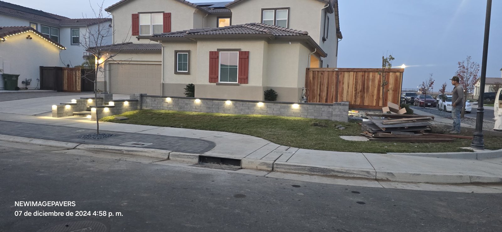 Evenly spaced lights trace the landscaped boundary along the street.