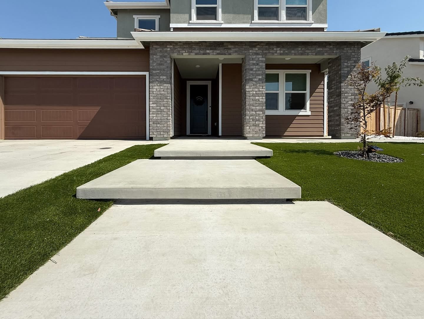 Large pale stepping surfaces form a contemporary route across the lawn.