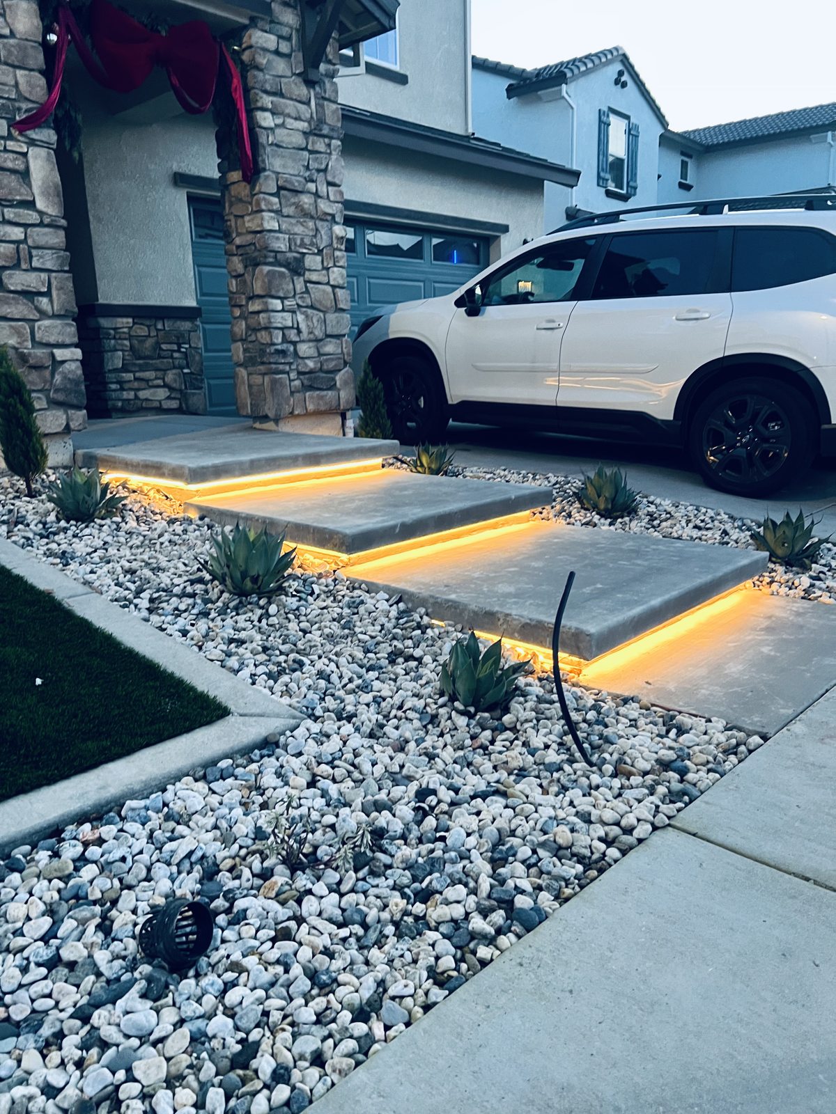 Warmly lit steps contrast with pale decorative stone at the entrance.