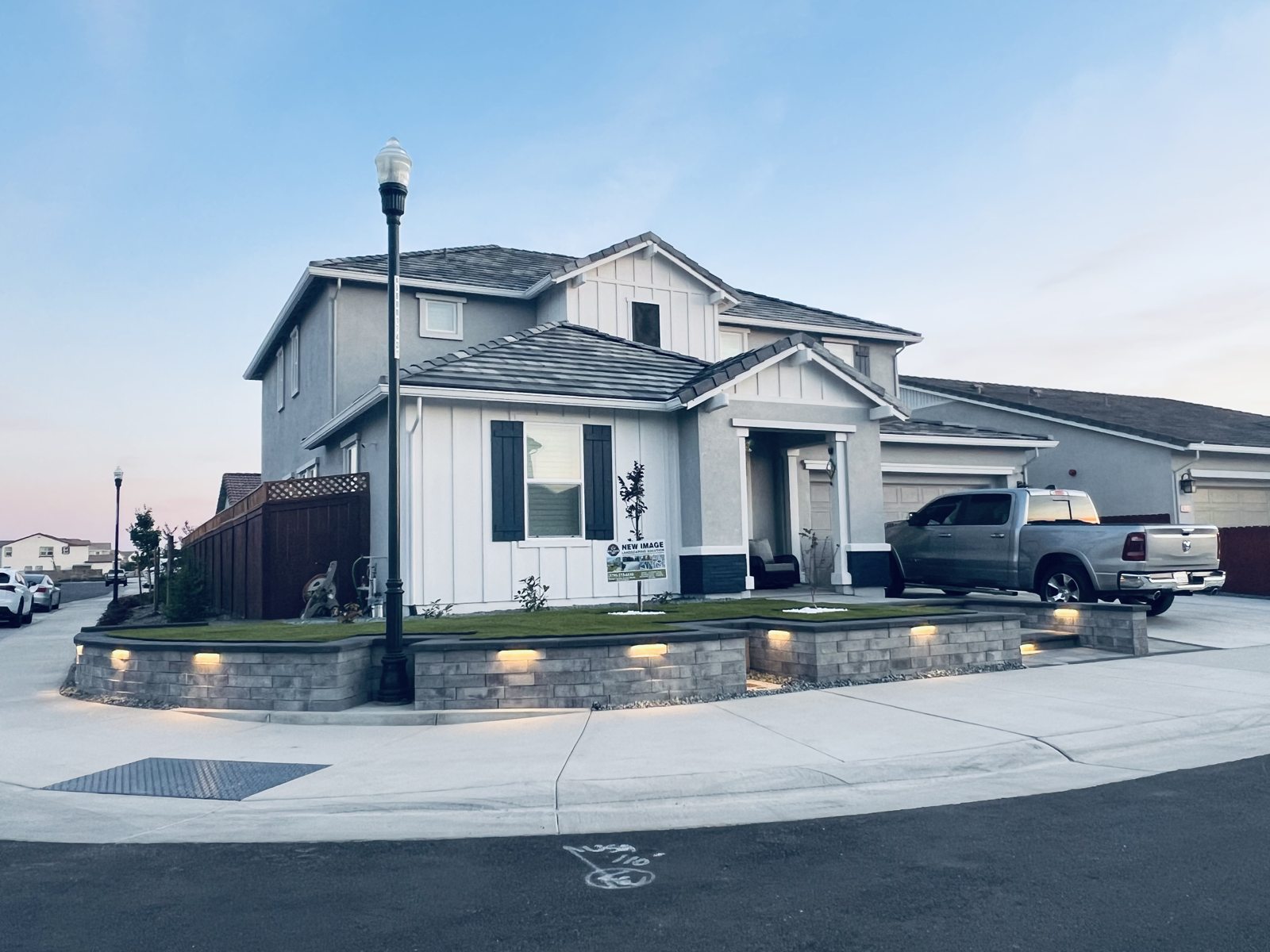 A corner-property view captures the home, driveway and layered front landscape.