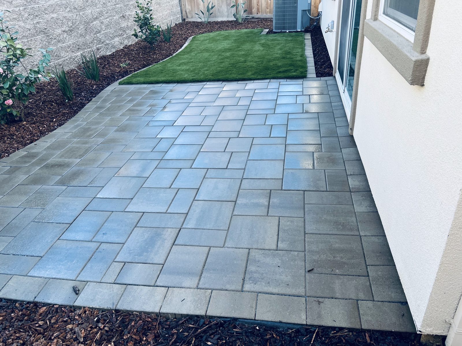 A carefully framed paver path creates a neat approach beside the lawn.