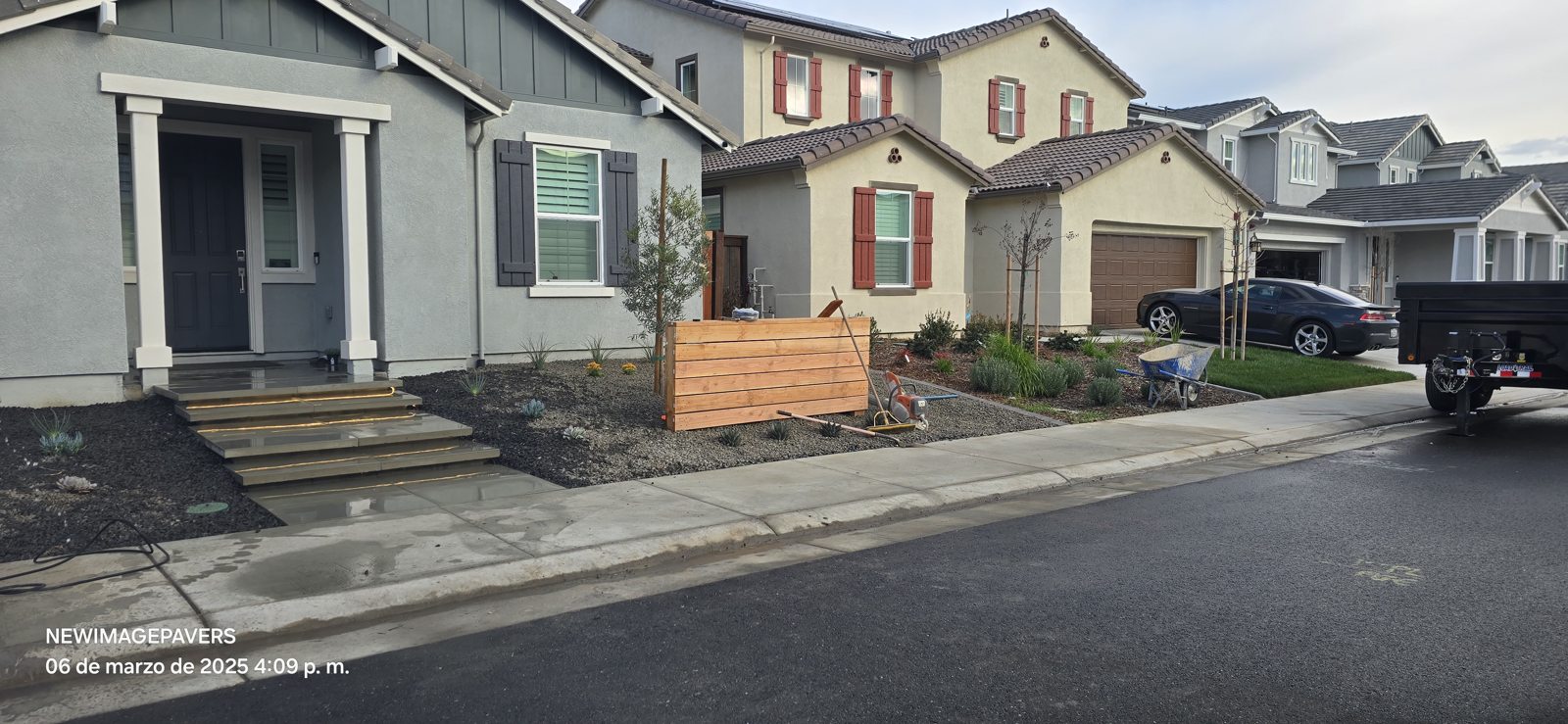 A wide view shows the finished relationship between the driveway and landscaped entry.