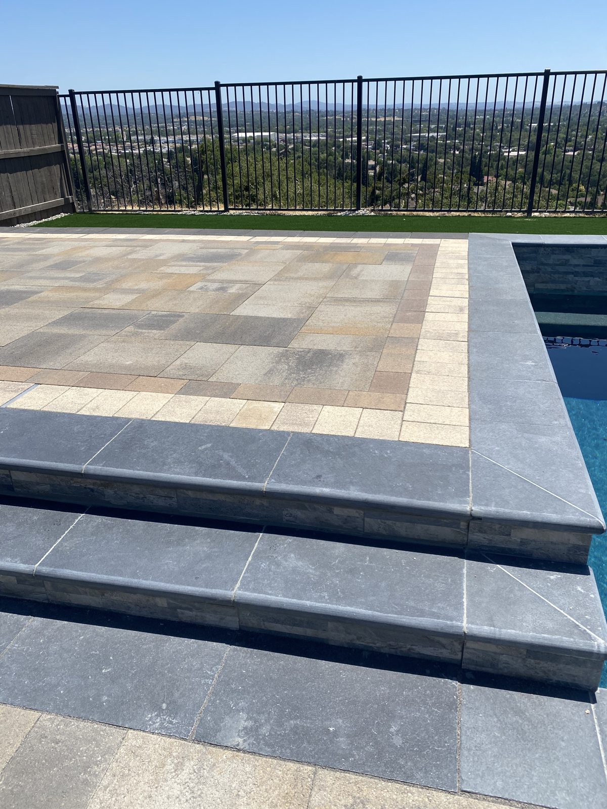 Broad paver steps create an elegant transition between outdoor levels.