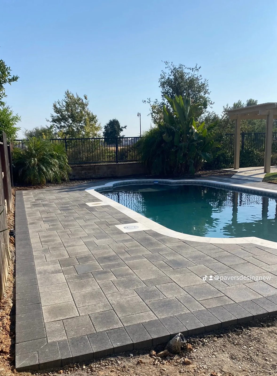 Poolside pavers provide a textured frame for a relaxed outdoor retreat.