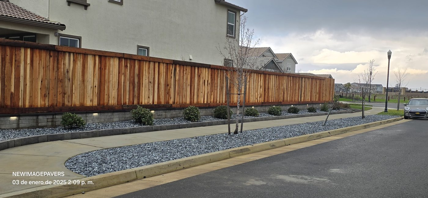 A long wood boundary and curved planting bed follow the street with a cohesive finish.