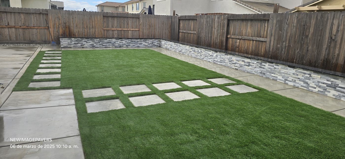 Wood fencing provides a warm backdrop to the geometric lawn and stepping surfaces.