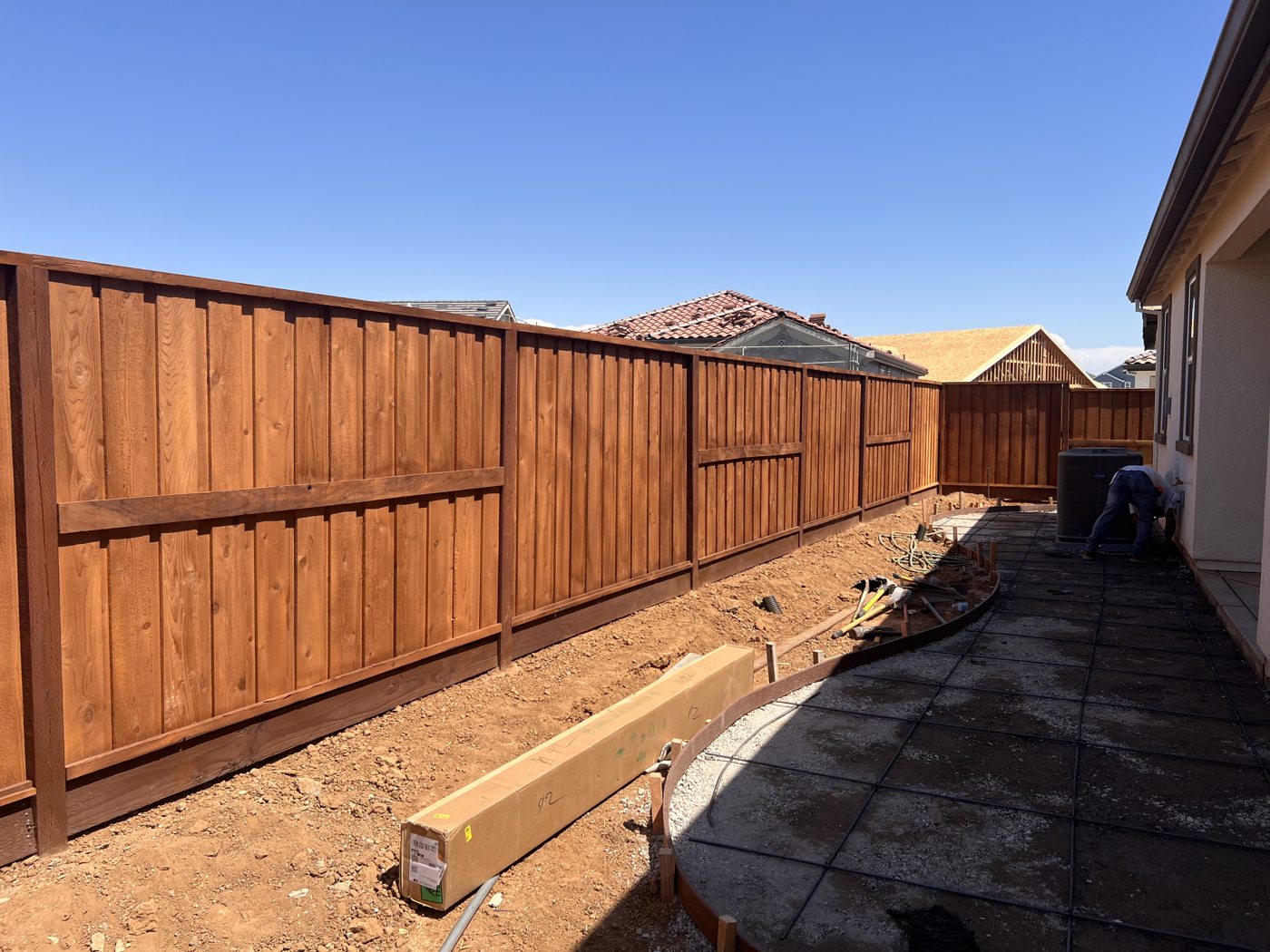 A rich wood finish brings consistent color to the long backyard fence.
