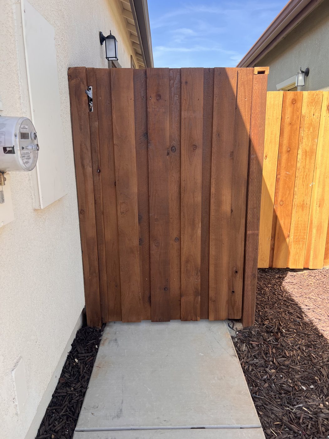 A solid wood gate creates a simple, private side entrance.