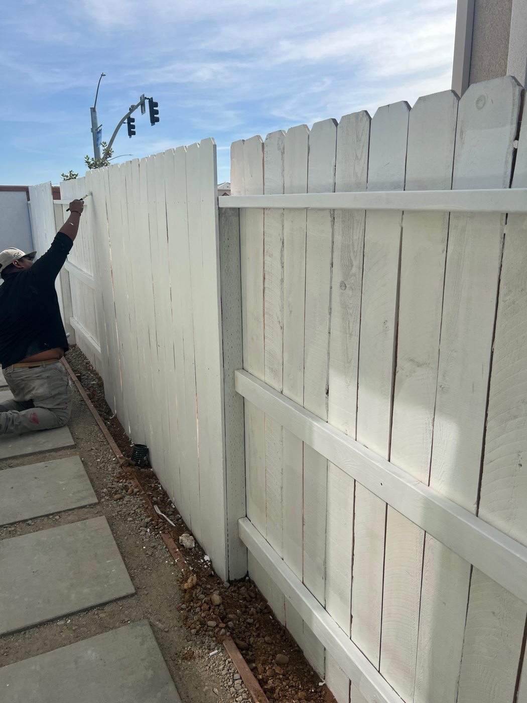 A light painted finish brightens the fence beside the garden walkway.